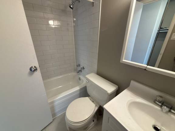 A white toilet sits next to a white sink in a bathroom.