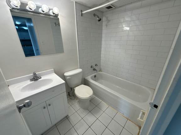 A white bathroom with a toilet, sink, and bathtub.