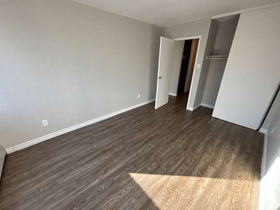 A room with wooden flooring and white walls.