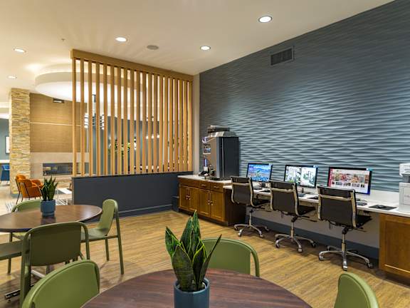 A modern office space with a wooden partition and multiple workstations.