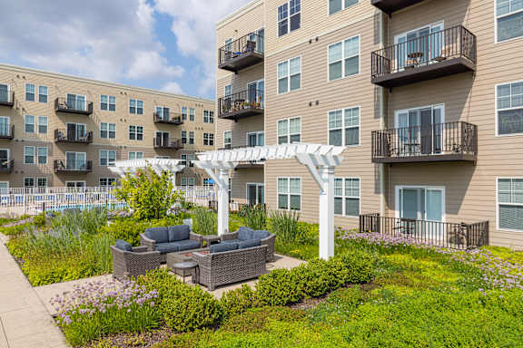 Apartment complex with a patio and a white umbrella.