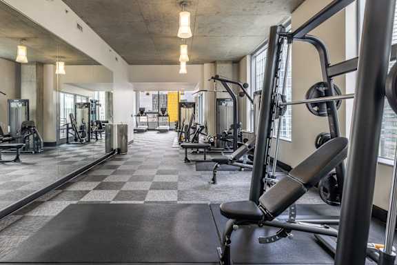 A gym with a variety of equipment including a bench press.