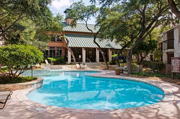 a large swimming pool with a house in the background