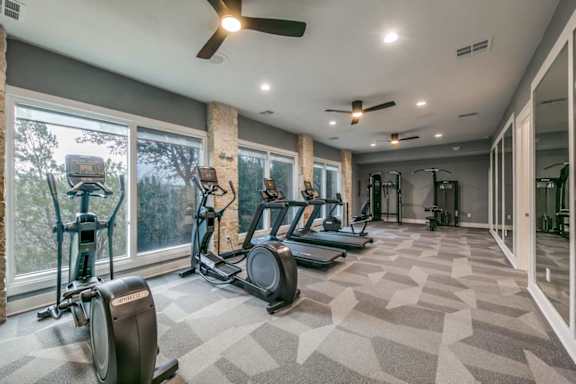 A spacious gym with treadmills, elliptical machines, and a fan at Canyon Ridge, Austin, TX, 78753
