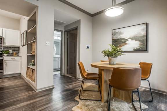 A dining area with a brown table and chairs.