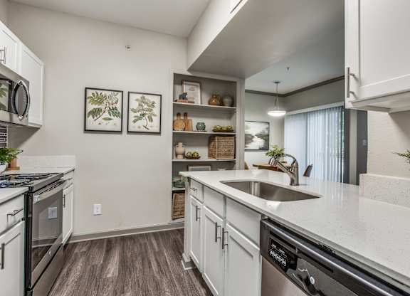 A modern kitchen with white cabinets and a black dishwasher.
