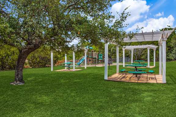 A playground with a swing set and a tree at Canyon Ridge, Austin, TX