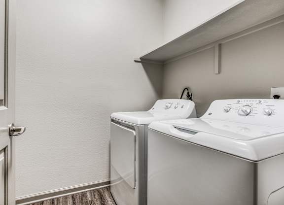 A white washing machine and dryer in a small laundry room.