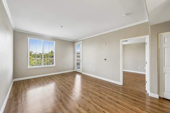 A large empty room with wooden floors and white walls.