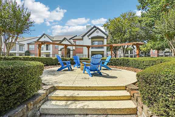 A building with a porch and blue chairs in front.