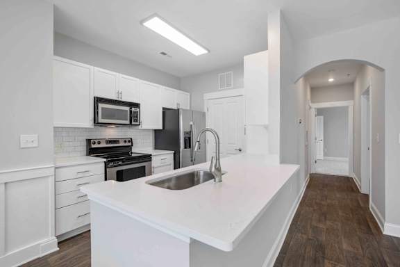A modern kitchen with white cabinets and a large island.