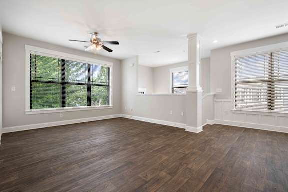 A room with wooden floors and a ceiling fan.