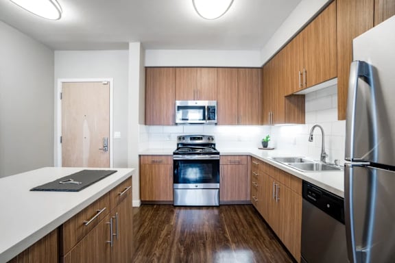 A modern kitchen with wooden cabinets and stainless steel appliances.