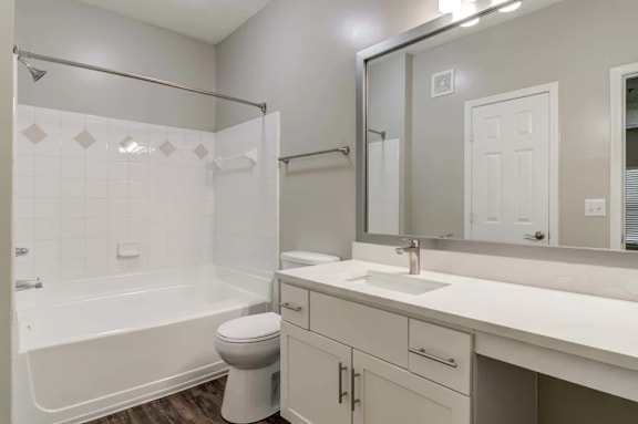A white bathroom with a toilet, sink, and bathtub.