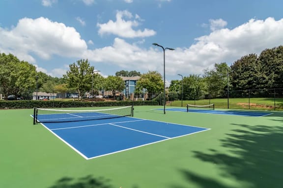A tennis court with a net and two players ready to play.