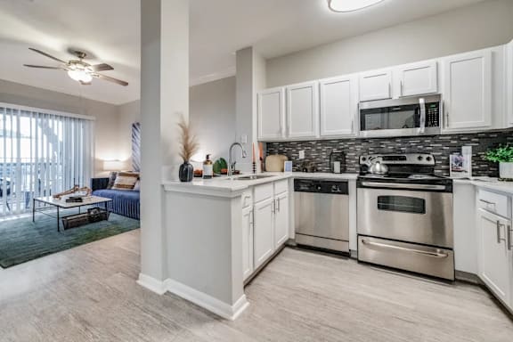 A modern kitchen with stainless steel appliances and white cabinets.