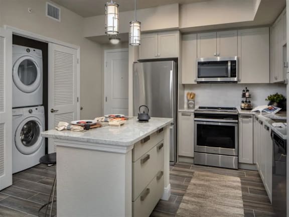A kitchen with a white countertop and stainless steel appliances.