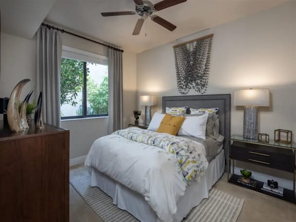 A bedroom with a large bed and a ceiling fan.