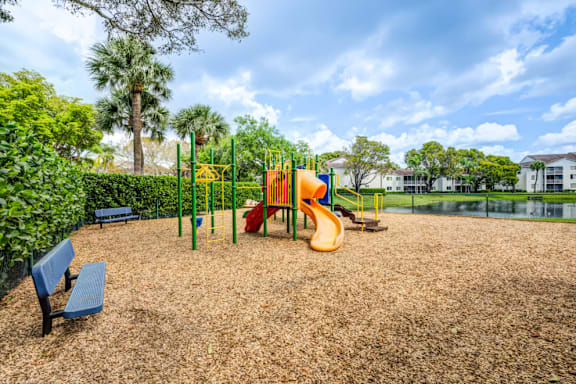 A playground with a slide, swings, and a bench.