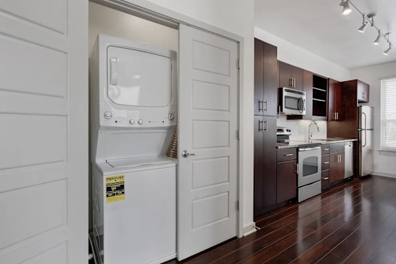 A white fridge is in a kitchen with a white door.
