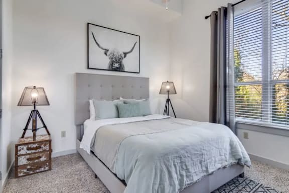 A bedroom with a large bed and a picture of a bull above it.