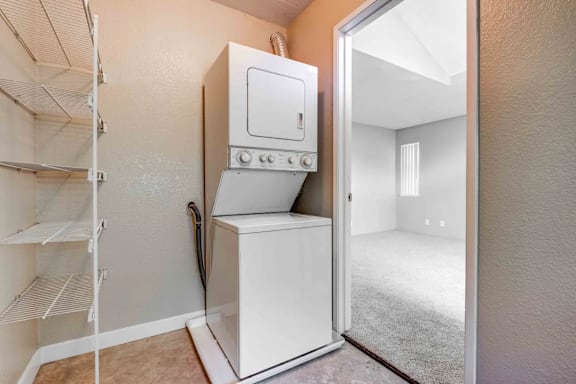 A small white stove is in a kitchen with a white fridge.
