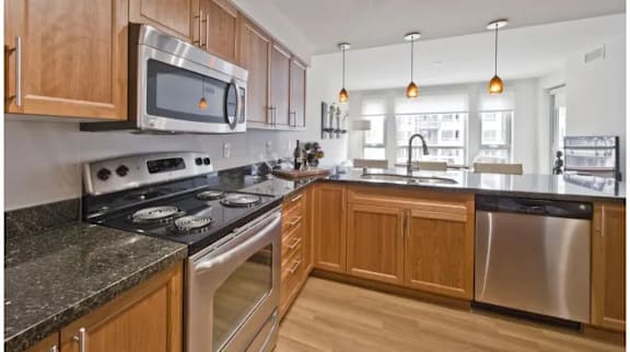 A modern kitchen with wooden cabinets and stainless steel appliances.