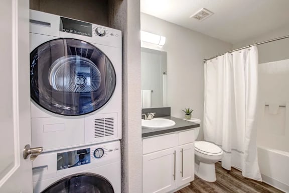 A white washing machine and dryer in a small bathroom.