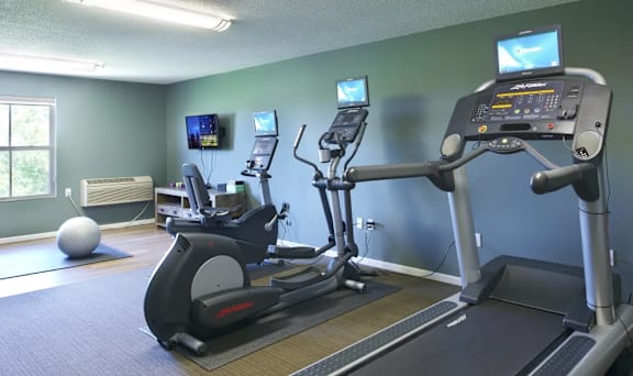A gym with treadmills and elliptical machines.
