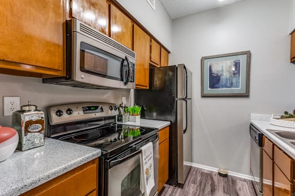 A kitchen with a stove, oven, microwave, and refrigerator.