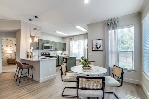 A modern kitchen with a dining table set for two.