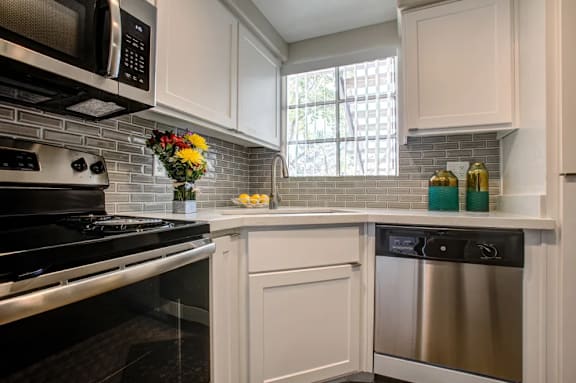 A kitchen with a black stove top oven and white cabinets.