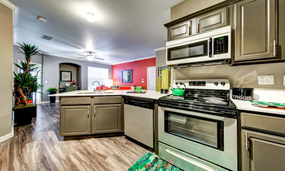 A kitchen with a stove, oven, and microwave.
