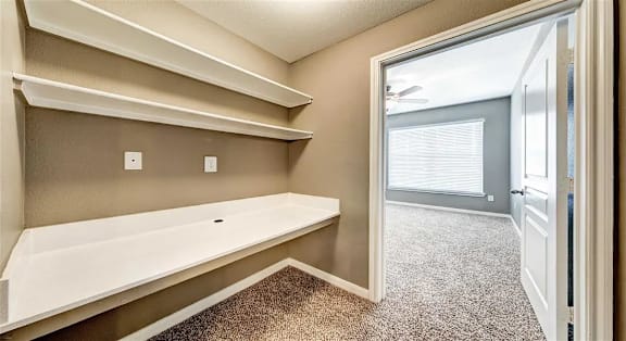 A room with a white bench and shelves.