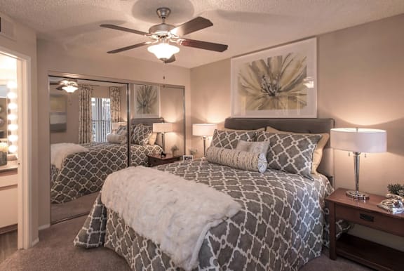 A bedroom with a large bed and a ceiling fan.