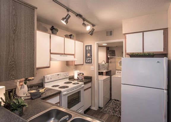 A kitchen with white appliances and wooden cabinets.
