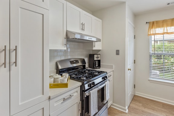 A kitchen with a stove top oven and a range hood.