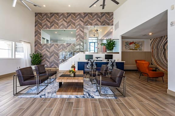A living room with a chevron patterned wallpaper and a wooden floor.