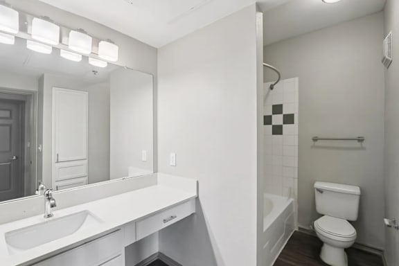 A white bathroom with a toilet, sink, and mirror.