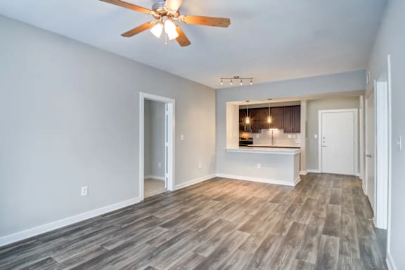 A room with a ceiling fan and wooden flooring.
