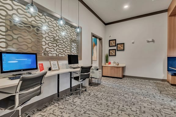 A modern office space with a computer, chair, and wall decorations.