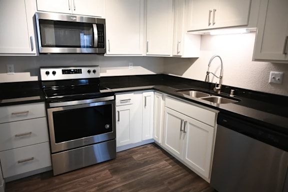 A modern kitchen with stainless steel appliances and white cabinets.
