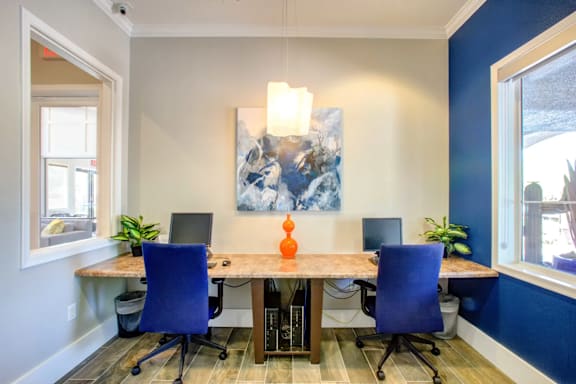 A room with a table and chairs and a painting on the wall.