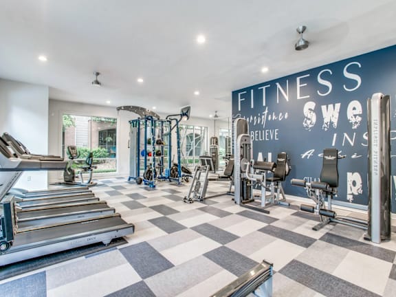A gym with a variety of equipment and a checkered floor.