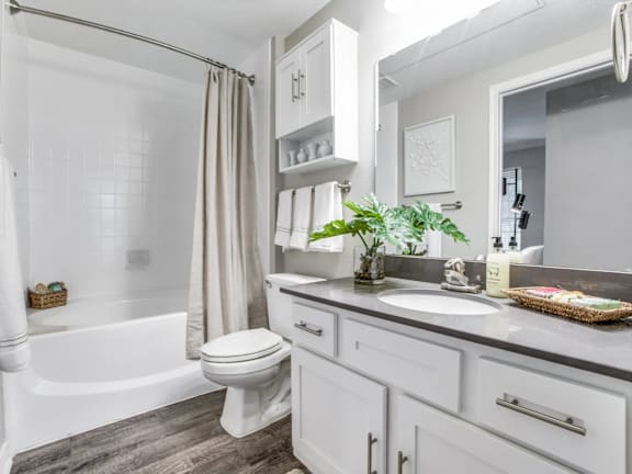 A white bathroom with a toilet, sink, and bathtub.
