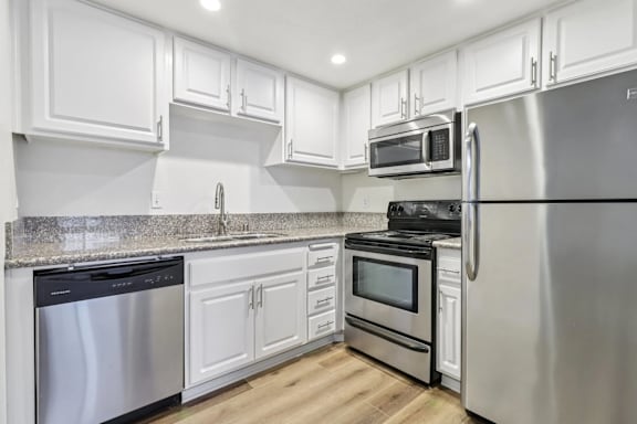 A kitchen with white cabinets and stainless steel appliances.
