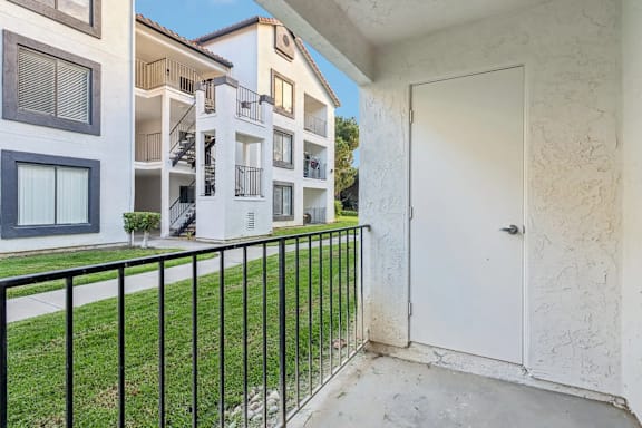 A white door is on the right side of a black railing.