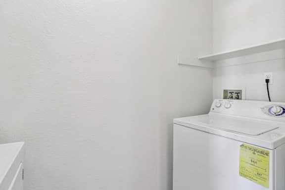 A white washing machine with a yellow sticker on it.