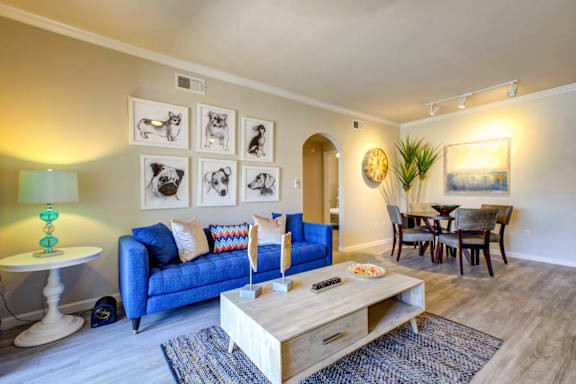 A living room with a blue couch and a wooden coffee table.