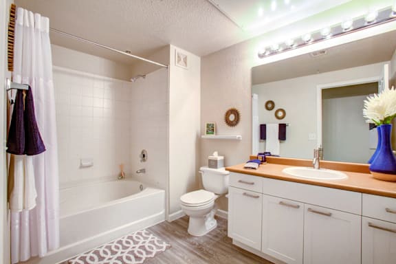 A white bathroom with a white tub, toilet, and sink.